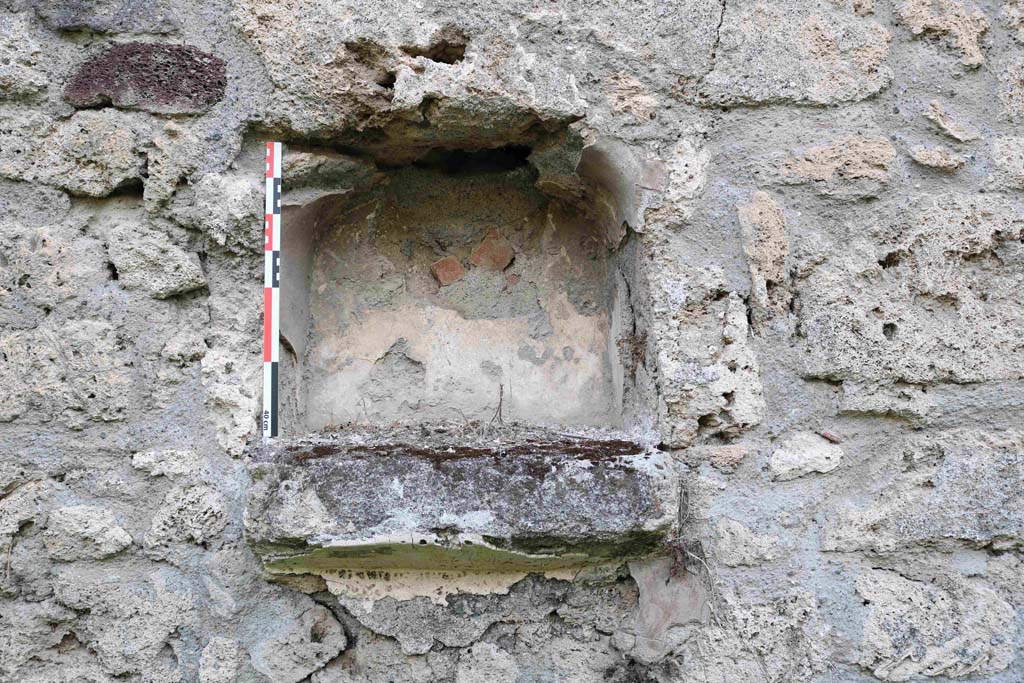 I.5.3 Pompeii. September 2018. Detail of niche in west wall. Photo courtesy of Aude Durand.
Boyce reported that there was an arched niche (h.0.45, w.0.45, d.020, h. above floor 0.80) in the west wall with projecting floor.
See Boyce G. K., 1937. Corpus of the Lararia of Pompeii. Rome: MAAR 14. (p.25, no. 34). 
