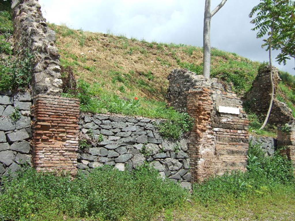 IV.2.e Pompeii. May 2006. Entrance. According to Liselotte Eschebach, there was a Lararium inside to the left. She suggested this was Boyce number 70. Boyce simply described a niche in the west wall for the domestic gods.
 See Boyce G. K., 1937. Corpus of the Lararia of Pompeii. Rome: MAAR 14. (p.31, no. 70).
See Eschebach, L., 1993. Gebäudeverzeichnis und Stadtplan der antiken Stadt Pompeji. Köln: Böhlau. (p.118, IV.2.5).
According to Sogliano, the walls of the workshop were coated with rough plaster, and offered nothing of interest except the niche of the domestic gods in the west wall. Many items that were discovered in the workshop are listed in NdS, pages 279-80.
Some of these items showing signs of burning from the fire that must have developed here.
See Notizie degli Scavi di Antichità, 1905 (p.279-80). 
