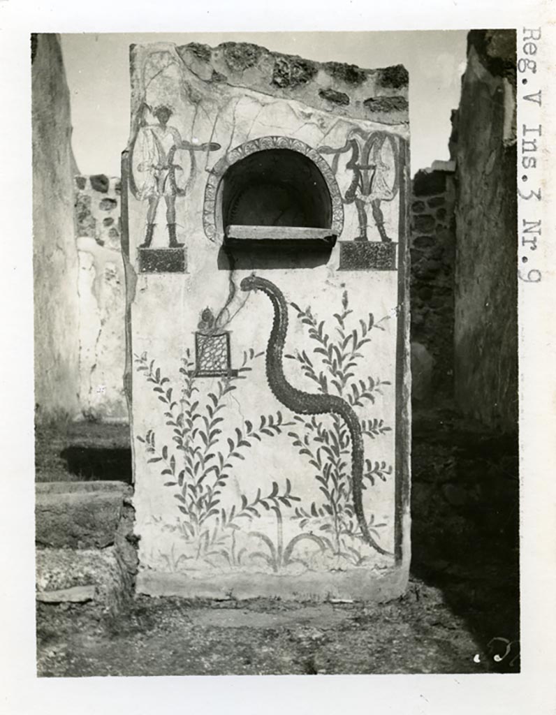 V.3.9 Pompeii. pre-1937-39. Lararium on north side of atrium, with 2 Lares dressed in short tunics.
Photo courtesy of American Academy in Rome, Photographic Archive. Warsher collection no. 551
Under the niche can be seen the serpent. A small marble altar was found inside the niche.
See Giacobello, F., 2008. Larari Pompeiani: Iconografia e culto dei Lari in ambito domestico. Milano: LED Edizioni. (p.239) 
