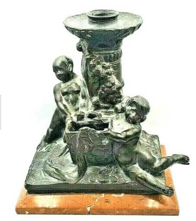 Bronze candlestick. Early 20th century. It has the signature of Gaetano Geraci and the stamp of the Fonderia Artistica Laganà Napoli
The Fonderia Artistica Laganà, one of the most important foundries in Naples, was founded in 1890 by Giovanni Amedeo Laganà, a patron and collector of art, who gathered around him the best specialists in wax casting, chiselling and bronze in Naples. 
In 1898, the sculptor Giuseppe Renda became its technical director. 
In 1907 the foundry was transformed into a joint-stock company and after the war it devoted itself to large monuments. 
It was frequented by the best Italian artists, including Vincenzo Gemito, who died there in 1929 as a result of the heat from a casting he was working on. 
The foundry continued its activity until more than the middle of the 20th century.


