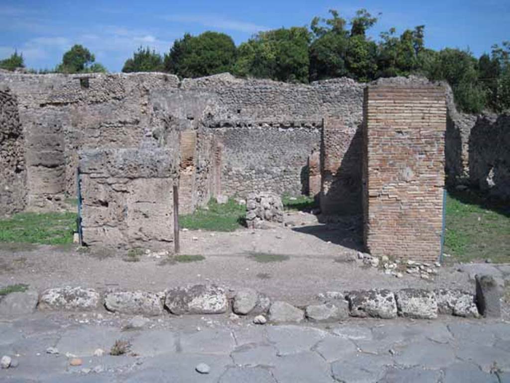 I.1.4 Pompeii. September 2010. Entrance, looking east east from Via Stabiana.Photo courtesy of Drew Baker.
According to Warscher, quoting Mau in Bull. Inst. 1875, p.29, 
I.1.4/5 - “Mentre le località servivano per i carri e per il bestiame da tiro e come camere da letto, lungo la strada, a sinistra dello ingresso, stanno altre località (nos.4 and 5) che evidentemente servivano da caupona per i carrettieri e per altri avventori.  Vi sono due locali con larga apertura sulla strada, a guisa di botteghe, congiunte mediante una porta, e in ciascuno di cui dà un’altra stanza con apertura larga anch’essa, queste ultime non congiunte fra di loro, mentre quella meridionale ha una porta su quel locale per cui si passa nel cortile. In mezzo al locale anteriore no.4 si trova una tavola di materiale piuttosto piccola, sulla quale si metteva senza dubbio una tavola più grande di legno per mangiare.  Avanti alla porta del locale no.5 e lungo il muro laterale della casa adiacente, che sporge un poco nella strada, vi è una panca di materiale, quale trovammo avanti alla caupona (also see I.1.6/9)
See Warscher T., 1936. Codex Topographicus Pompeianus: Regio I.1, I.5. (no.13), Rome: DAIR, whose copyright it remains.
(translation: “While the locality served for wagons and animals and as sleeping accommodation, along the road, to the left of the entrance, were other places (nos. 4 and 5) that evidently served as caupona for the carters and other patrons.  There were two rooms with a wide opening onto the road in the guise of shops, joined through a door, and in each of which had another different room also with a wide opening, these last did not join each other, while the southern one had a door which passed into the courtyard.  In the middle of the front room of no. 4 was a table of material, rather small, on which one would undoubtedly have placed a larger wooden table for eating. Before the door of the premises no. 5 and along the side wall of the adjacent house, which protruded a little into the street, there was a bench of material, which was found before the caupona”.)