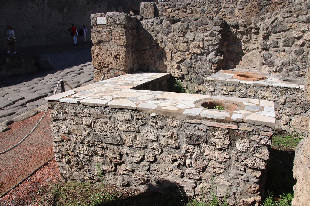 I.2.8 Pompeii. October 2024. Looking north across counters towards niche in north wall. Photo courtesy of Klaus Heese.