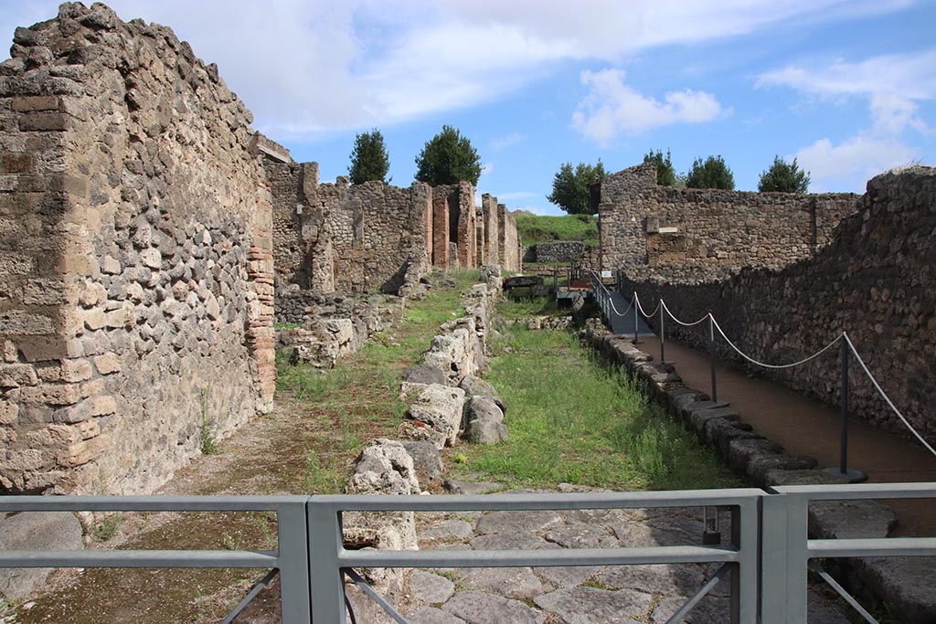 I.2.32 Pompeii, on left. October 2024. Looking east along Vicolo del Conciapelle towards Vicolo del Citarista. Photo courtesy of Klaus Heese.