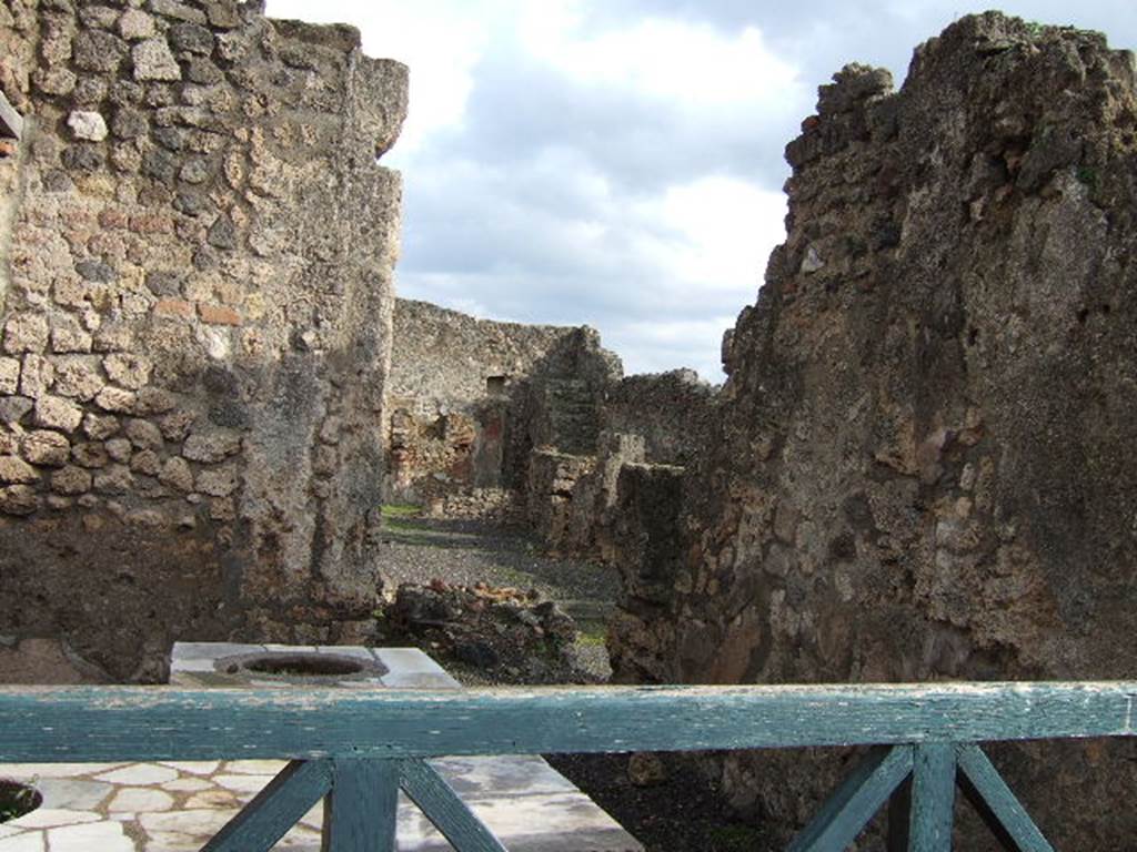 I.4.2 from I.4.3 Pompeii. May 2005.   The remains of a hearth in the atrium can be seen by looking over the counter.