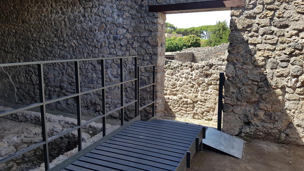 I.5.2 Pompeii. August 2023. 
Looking west from industrial back room with fifteen vats towards doorway and steps down. Photo courtesy of Maribel Velasco.
