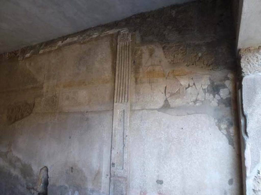 I.6.7 Pompeii. December 2005. East wall of triclinium. On the east wall is a stucco partition in relief, dividing the antechamber and the triclinium. The lower third was painted in red and the part above with a recess which was adorned with floral candelabra with plates.
