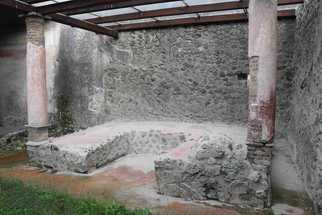 I.8.9 Pompeii.  March 2009.  Room 9 and Garden area.  Triclinium against east wall with two red painted columns built on the couches.
These columns supported a pergola above the triclinium.
