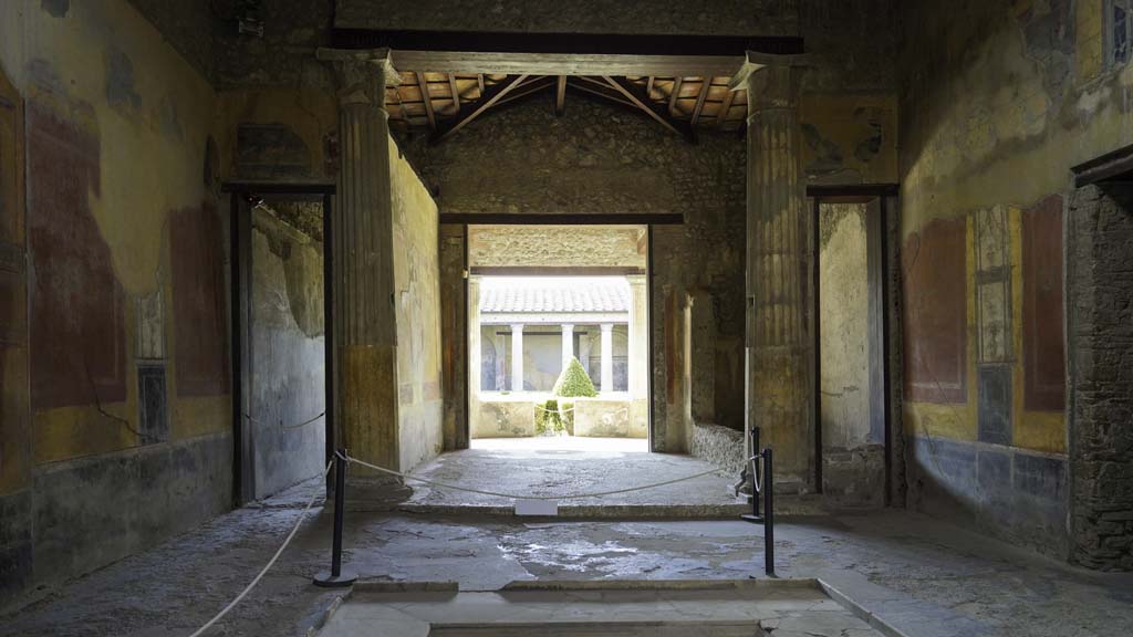 I.10.4 Pompeii. September 2015.  Atrium, on the south wall above doorway to corridor 9.  Painting of a dog chasing a deer.
