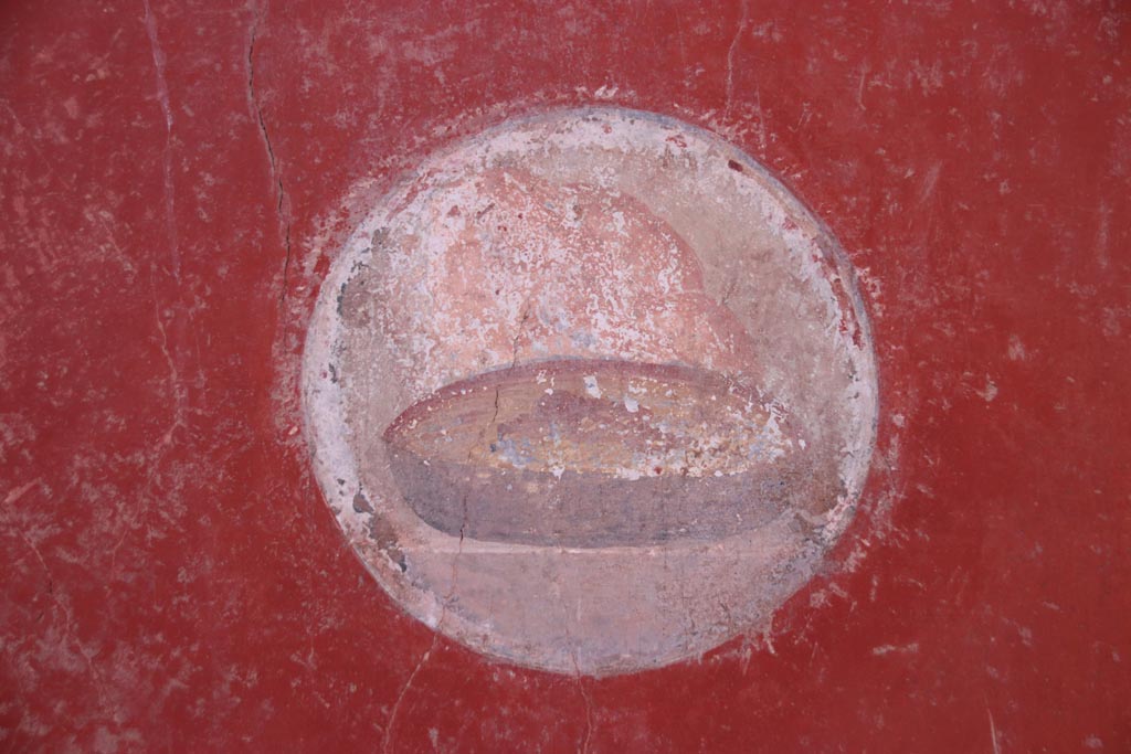 I.10.11 Pompei. October 2022. 
Room 2, painted medallion of bread from west wall in north-west corner of atrium. Photo courtesy of Klaus Heese.
