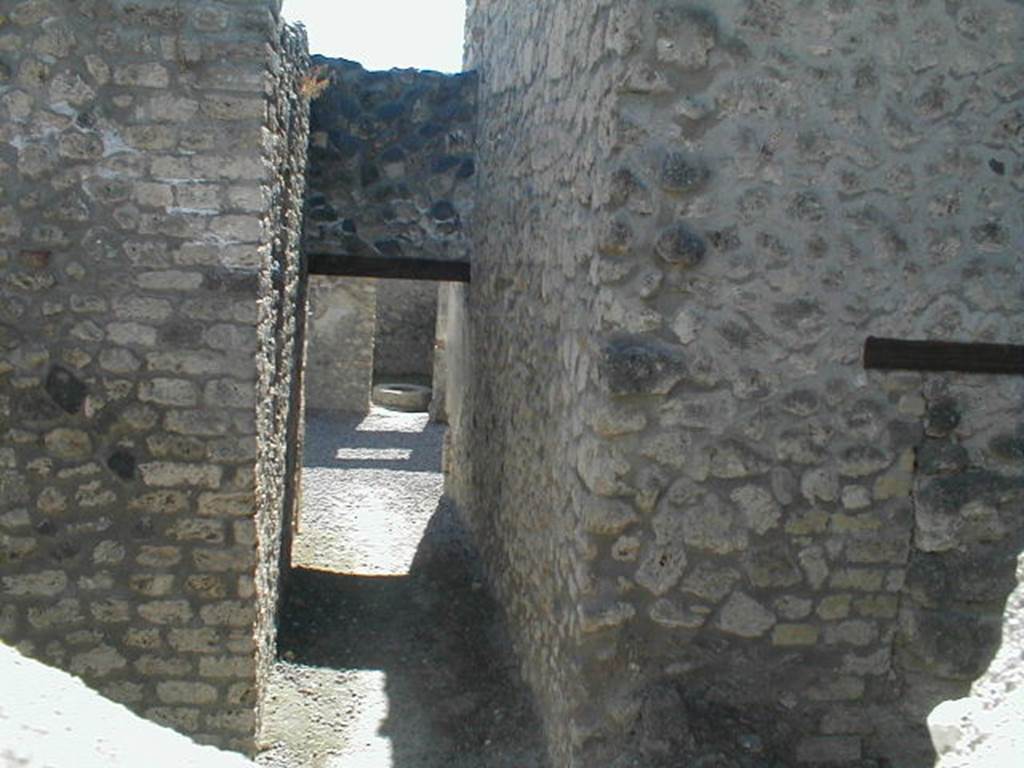 I.11.8 Taken through hole in wall, looking west along corridor towards the garden.