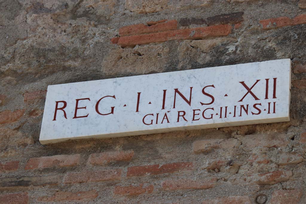 I.12.5 Pompeii, east side façade onto Vicolo dei Fuggiaschi. September 2017.
Insula identification plaque, Reg. I. Ins. X11, previously known as Reg. II, Ins. 11 (which is Reg. II, Ins. 2). 
Photo courtesy of Klaus Heese.
