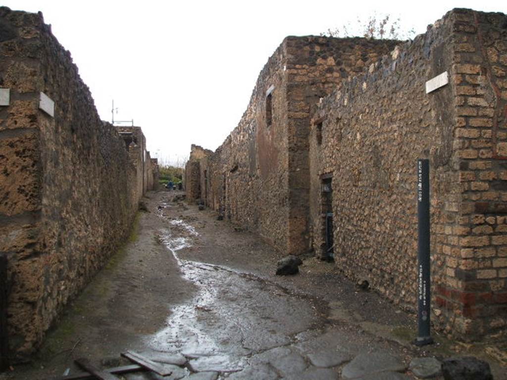I.11 Pompeii. December 2004. Roadway looking north, showing I.12.13 and side wall of I.12.12 