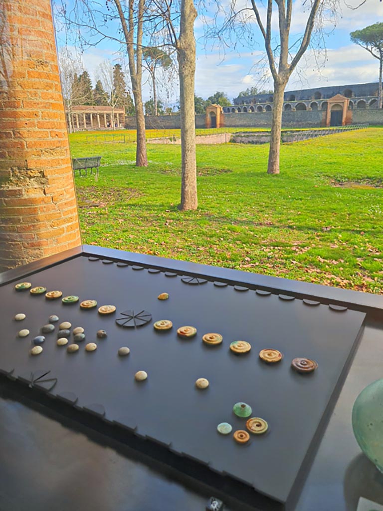 I.13.5 Pompeii. March 2024. Items found in a wooden crate in rear room. Photo courtesy of Giuseppe Ciaramella.
3. Game set. (set out on No. 4, Reproduction of a board for the game of the twelve signs.)
On display in exhibition in Palaestra entitled – “L’altra Pompei, vite comuni all’ombra del Vesuvio”.
