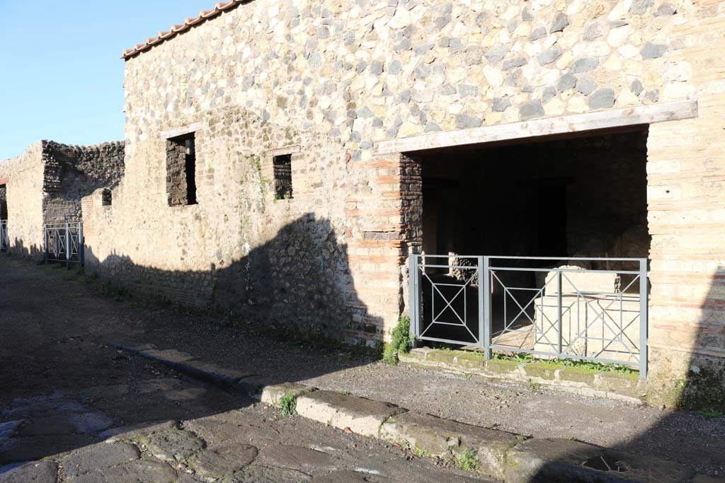 I.14.15 Pompeii. December 2018. Looking north-west on Via della Palestra towards entrance doorway. Photo courtesy of Aude Durand.
According to Giordano and Casale, found on 20th October 1957, on the west side of the entrance was -

CEIVM II VIR EQVITIVS ROG
ET HELVIVM SABINVM
AED OVF      [GC4]

According to Cooley, this was from I.14.11 and translates as –

Equitius asks you to elect Ceius duumvir and Helvius Sabinus aedile.

See Giordano, C. & Casale, A: Iscrizioni Pompeiane Inedite scoperte tra gli anni 1954-1978: Atti Acc Pont NsS 39, 1990 (1991), p. 277, no. 4.
See Cooley, A. and M.G.L., 2014. Pompeii and Herculaneum: A Sourcebook. London: Routledge, F69, p. 177.
See Eschebach, L., 1993. Gebäudeverzeichnis und Stadtplan der antiken Stadt Pompeji. Köln: Böhlau, p. 71.
