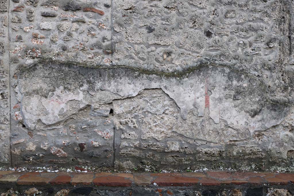 I.16.3 Pompeii. December 2018. 
Front façade wall on west of entrance doorway, remains of painted plaster decoration. Photo courtesy of Aude Durand.
