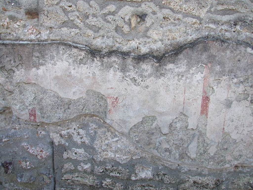 I.16.3 Pompeii. December 2006. Detail of remains of painted plaster on outside wall.