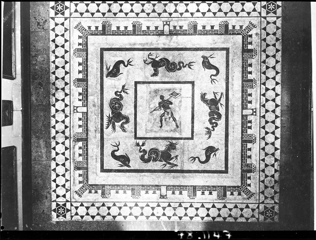II.4.6 Pompeii. Black and white mosaic showing a furnaceman and a marine scene set in floor of Naples Museum.
DAIR 78.1147. Photo © Deutsches Archäologisches Institut, Abteilung Rom, Arkiv. 
According to Marietta de Vos, this was provenanced from the baths of the Praedia di Julia Felix and is now in the floor of Naples Archaeological Museum, piano nobile, giro interno, Sala III, pavimento. 
See Dell’Orto, L. F. (ed), 1993. Ercolano 1738-1988: 250 anni di ricerca archeologica: Atti del Convegno internazionale. SAP Monografie 6, p. 115, pl. XXII.
There is a photo of a mosaic with a similar castellated pattern (but with a different centre) in VI.1.7/25, which presumably would have been found a few years later, after this one. The mosaic would have been seen in Gli Ornati (pt.2.1808, and also 1838). 
See Gli ornati delle pareti ed i pavimenti delle stanze dell'antica Pompei incisi in rame: 1808 and 1838, no. 41.


