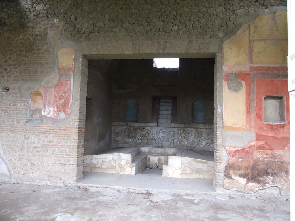 II.4.6 Pompeii. December 2006. Summer triclinium with cascade fountain, looking west from portico.
The niche on the left of the doorway was described as in “ambiente 85”.
In May 1755, near 85 a small niche in the wall of the portico, 47 fragments of terracotta were found in the ash, relating to two figures.
When restored, they showed la Carita Romana, the roman charity.
Now in Naples Archaeological Museum, inventory number 22580.
See Pagano, M. and Prisciandaro, R., 2006. Studio sulle provenienze degli oggetti rinvenuti negli scavi borbonici del regno di Napoli. Naples: Nicola Longobardi. 
(Vol.1, p.16 dated 1st June 1755, and Vol.2, p.341, fig.93 in Rami inediti)
