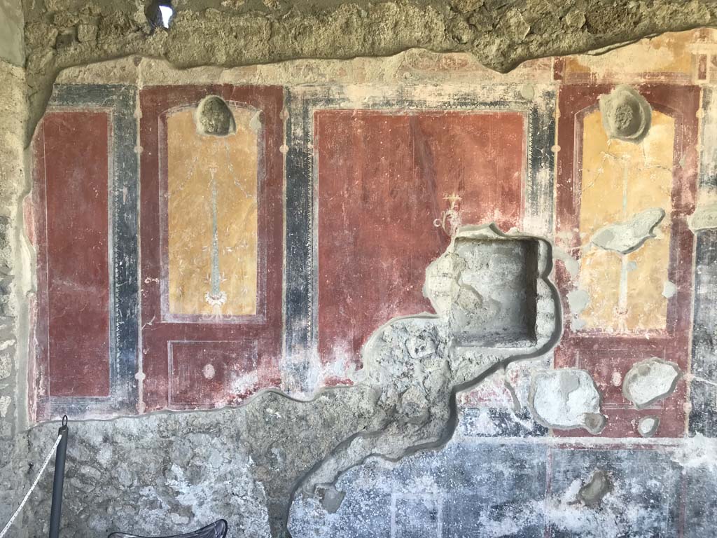 II.4.6 Pompeii. April 2019. 
Detail of west wall of portico at its southern end, near doorway to II.4.10, on left. Photo courtesy of Rick Bauer.  

