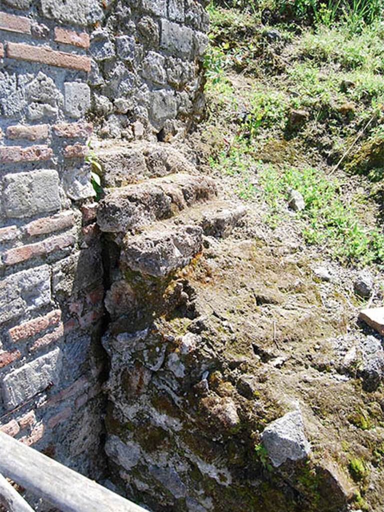 II.5.1 Pompeii. May 2014. Left side of entrance doorway with stepped shelves on the remains of the serving table or counter. Photo courtesy of Paula Lock.
