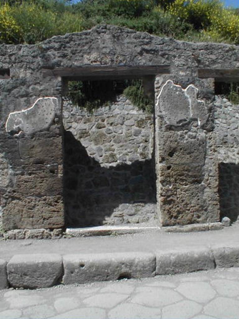 III.1.3 Pompeii. May 2005. Entrance doorway, partly excavated
According to Della Corte, on the pilaster to the left, between III.1.2 and 3, was written -
Cn(aeum) Hel[vium] Sabin(um)
aed(ilem) Pacuvius cu[pi]dus rog(at)     [CIL IV 7595]
See Della Corte, M., 1965.  Case ed Abitanti di Pompei. Napoli: Fausto Fiorentino. (p.342)
According to Cooley, this translates as 
Pacuvius eagerly asks for Cn. Helvius as aedile.
See Cooley, A. and M.G.L., 2004. Pompeii : A Sourcebook. London : Routledge. (p.121, F38)
Della Corte also said that on the right pilaster, above an old plaster but brought to light by the fall of the most recent plaster, was painted a large red anchor.  He thought this may have alluded to the activity of the proprietor, perhaps in maritime commerce. Today, the anchor is no longer visible.
