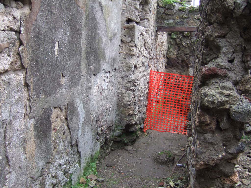 V.1.11 Pompeii. December 2005. Looking west along corridor, towards room with niche on south wall, according to Boyce.
This niche was ruined but had traces of painting visible on its walls.
See Boyce G. K., 1937. Corpus of the Lararia of Pompeii. Rome: MAAR 14. (p.32, no.76).
In this same room, in the latrine in the north-east corner, Sogliano reported a painting of Vesta. 
See Boyce G. K., 1937. Corpus of the Lararia of Pompeii. Rome: MAAR 14.  (p.32, no.77)
See Sogliano, A., 1879. Le pitture murali campane scoverte negli anni 1867-79. Napoli: (p.16, no.43)

