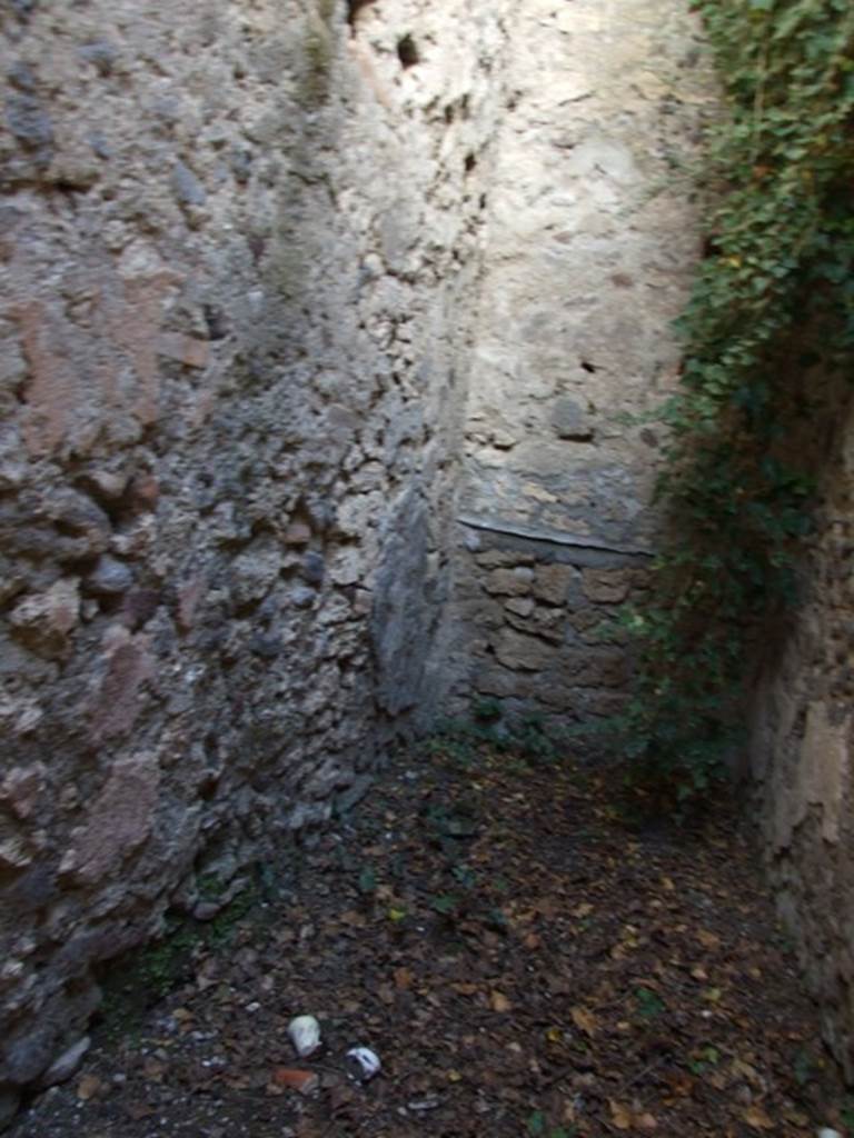 V.2.7 Pompeii. December 2007. Room 16, looking east along north wall towards east wall.
According to Mau 
The hearth was found on the left of the entrance doorway, and the latrine was at the rear.
BdI, 1895, (p.42)
