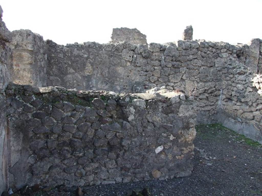 V.2.7 Pompeii. December 2007. Looking west from atrium towards low wall of rear room of shop V.2.6, on left. Room 2 which is open from the atrium is on the right.
