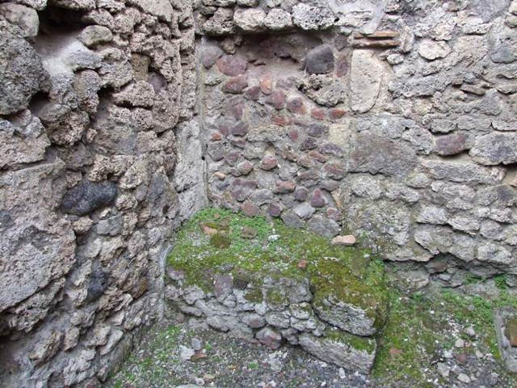 V.2.13 Pompeii. March 2009. Kitchen with hearth in north-west corner.
According to Boyce, above the hearth was a badly preserved lararium painting. The Genius was represented sacrificing at an altar. On each side stood a Lar, but only the one on the right was preserved. Further to the right a serpent approached an altar. The description was from Sogliano published in 1879. Reports in periodicals published in 1894 and 1896 mention only an altar as being visible in a painting.  Today, nothing remains.
See Boyce G. K., 1937. Corpus of the Lararia of Pompeii. Rome: MAAR 14. (No. 92 on p34)
See Sogliano, A., 1879. Le pitture murali campane scoverte negli anni 1867-1879, Naples. 

