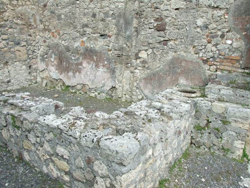 V.2.13 Pompeii,  March 2009.  Podium or bar counter, with remains of four urns, and small display shelving area.