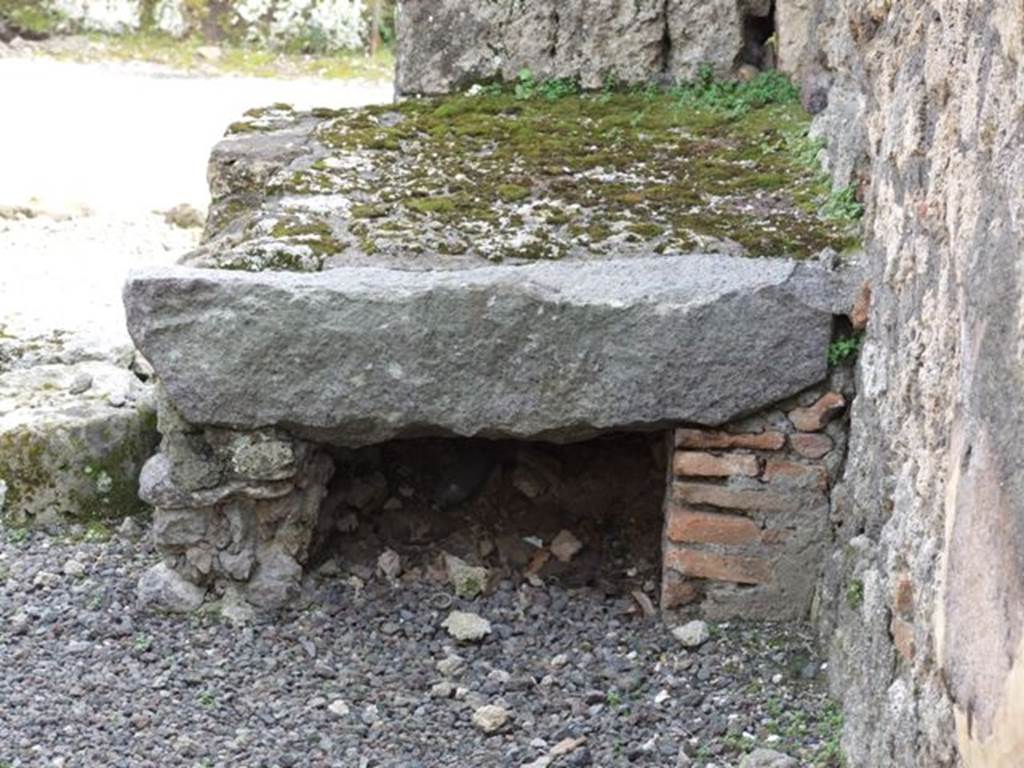 V.2.13 Pompeii. March 2009. South-west corner of thermopolium. 
According to Mau, he could believe that the remains of the material to the left of the entrance were a hearth. Above this was painted the usual serpent, although only the right side was conserved.  Also against the left wall were the very steep stairs to the upper rooms. Also found was a small cylindrical travertine altar, used no doubt for the sacrifices before the lararium (see V.2.14 for a note by Boyce).. 
See Mau, A., 1894. Mitteilungen des Kaiserlich Deutschen Archaeologischen Instituts, Roemische Abtheilung Volume VIII. (p.49)
According to Boyce, above the hearth was a badly preserved lararium painting. The Genius was represented sacrificing at an altar. On each side stood a Lar, but only the one on the right was preserved. Further to the right a serpent approached an altar. 
This description was from Sogliano published in 1879. Reports in periodicals published in 1894 and 1896 mention only an altar as being visible in a painting. Today, nothing remains. 
See Boyce G. K., 1937. Corpus of the Lararia of Pompeii. Rome: MAAR 14. (No. 92 on p34)
See Sogliano, A., 1879. Le pitture murali campane scoverte negli anni 1867-1879, Naples. (p.12, no.20)
 

