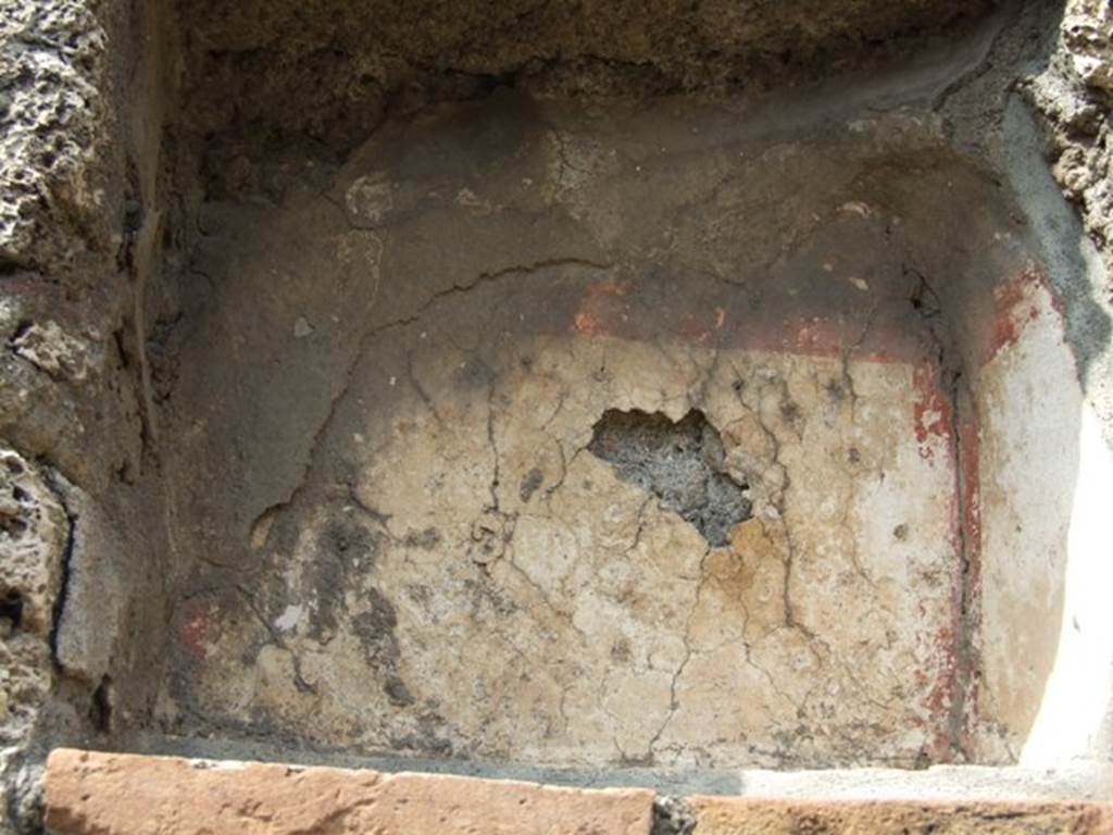 V.2.14 Pompeii.  March 2009. Niche with remains of stucco, walls painted white and with red stripes around the edges.