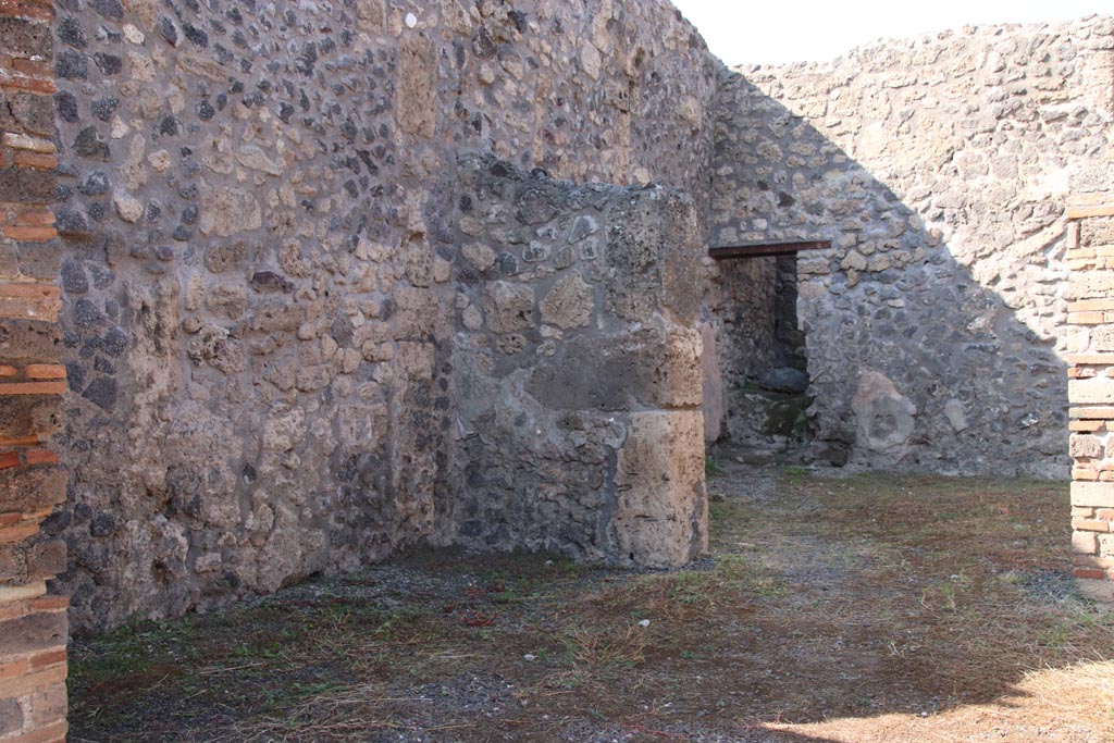 V.2.17 Pompeii. October 2022. West wall of shop-room, with doorway into middle room in north wall. Photo courtesy of Klaus Heese.