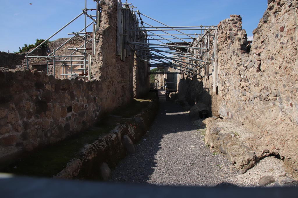 V.2.20 Pompeii, centre left, lit by sunlight. October 2022. 
Looking north along Vicolo dei Balconi, from junction with Via di Nola. Photo courtesy of Klaus Heese.
