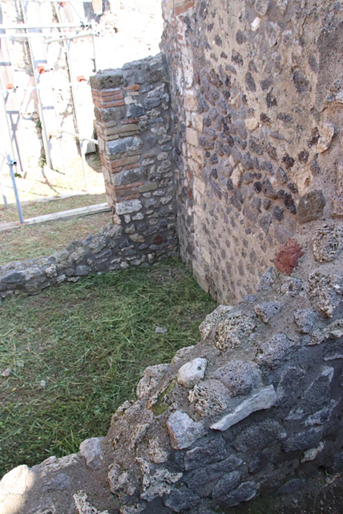 V.2.19 Pompeii. October 2022. 
Looking towards south-east corner of small room, with window into rear room.
Photo courtesy of Klaus Heese.
