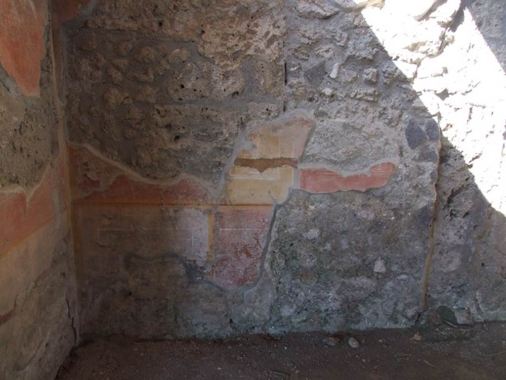 V.3.4 Pompeii. March 2009. Front room on east side of tablinum. North-west corner and north wall. According to Sogliano, this room was covered by a barrel-vaulted roof, and had a window overlooking the garden area and its floor was of opus signinum. Fragments of marble slabs were scattered in the opus signinum, and in the centre was a kind of star enclosed in a panel, both made from small dark marble tesserae. The plastered walls were covered with large red panels divided by large yellow stripes or pilasters, with a white frieze.
The base of the wall was divided into alternate black and red panels. See Notizie degli Scavi di Antichit, 1905, (p.208)


