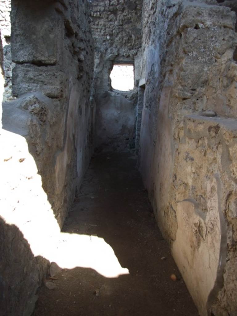 V.3.4 Pompeii. March 2009. Corridor leading east, to small room on the south side.
According to Sogliano, this corridor on the north side of the front room had wooden door-jambs at the entrance. The walls were lined with rough plaster with a high brick plinth.
On the right, immediately upon entering the corridor, he saw a small niche which had side walls clad in wood. Facing it in the left wall was a rectangular window, fitted with the equal of a sill and jambs made of wood. A second window was at the end of the corridor.
A doorway at the end led into a small room or cupboard. See Notizie degli Scavi di Antichit, 1905, (p. 209)

