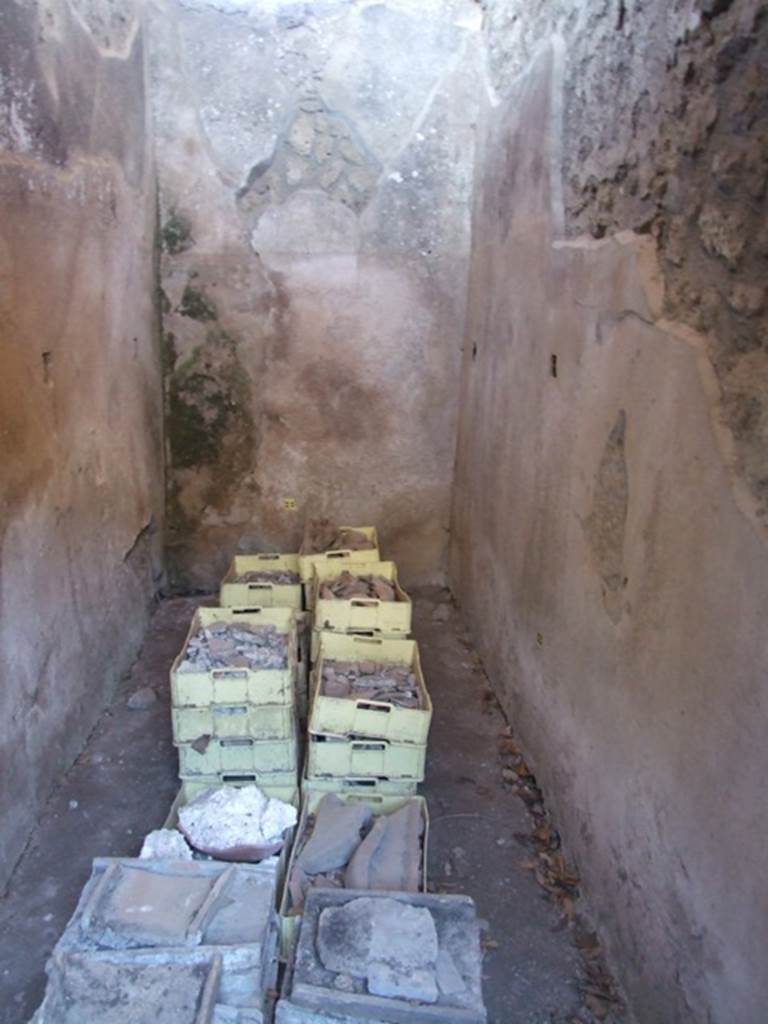 V.3.4 Pompeii. March 2009. Small room with remains of shelving supports. According to Sogliano, the small room on the south side of the end of the corridor was covered with a roof. The roof tilted outwards, and some roof tiles remained in situ. The flooring was of broken brick pieces, and the walls covered with rough plaster, with high brick plinth. Found in the east and west walls, at a height of 1.20m from the flooring, were three square holes for each wall. These holes were decorated with a yellow band around them, and were intended to hold the wooden shelving supports. However as there was no trace of either on the walls, he believed they had not yet been put into place. See Notizie degli Scavi di Antichit, 1905, (p. 209-10)
