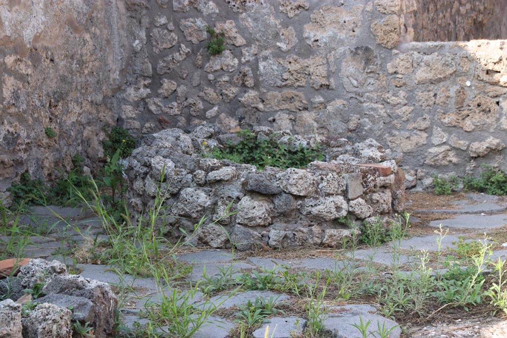 V.3.8 Pompeii. October 2023. Remains of base of mill in north-west corner. Photo courtesy of Klaus Heese.