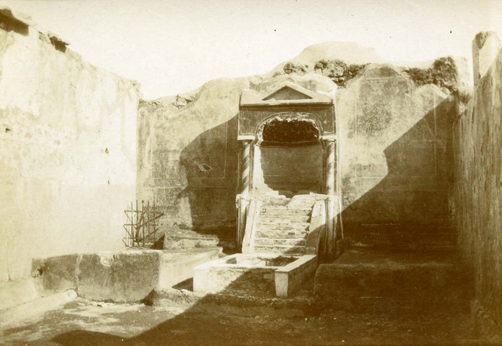 .3.11 Pompeii. 1903. Looking towards south wall of the garden with aedicula fountain niche, pool and biclinium.
Photo by Esther Boise Van Deman (c) American Academy in Rome. VD_Archive_Ph_213.
According to Soprano –
Ubicazione: viridario. L. summus e l. imus, m.300.
Bibliog. Thedenat, op. c. p.82, fig. 82; “Not Scavi”, 1902, p. 276 e 372.
Il posto del l. medius era occupato da un ninfeo. 
Tra i letti laterali c’era una vasca rettangolare dal cui centro si innalzava un getto d’acqua, ed entrambi i letti laterali erano forniti di piccole conduttore interne per lo scolo delle acque (Note: In una pianta della casa, riprodutta in “Not.Scavi” 1902, p.312, era indicato il corso delle fistulae che portavano l’acqua alle due fontane).
Ai lati del ninfeo, sulla parete di fondo, s’estendeva una figurazione paesistica con un serpente e un cicogna tra alberi.”
See Soprano, P. (1950). I triclini all’aperto di Pompei. (In Pompeiana, raccolta di studi per il secondo centenario degli scavi di Pompei. Napoli, Gaetano Macchiaroli, Editore, P. 306, no.27).

