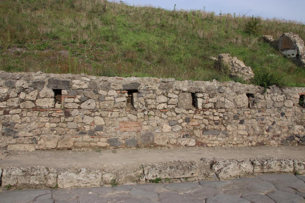 V.6.5 Pompeii. October 2022. Looking east to front wall on east side of Via del Vesuvio. Photo courtesy of Klaus Heese.