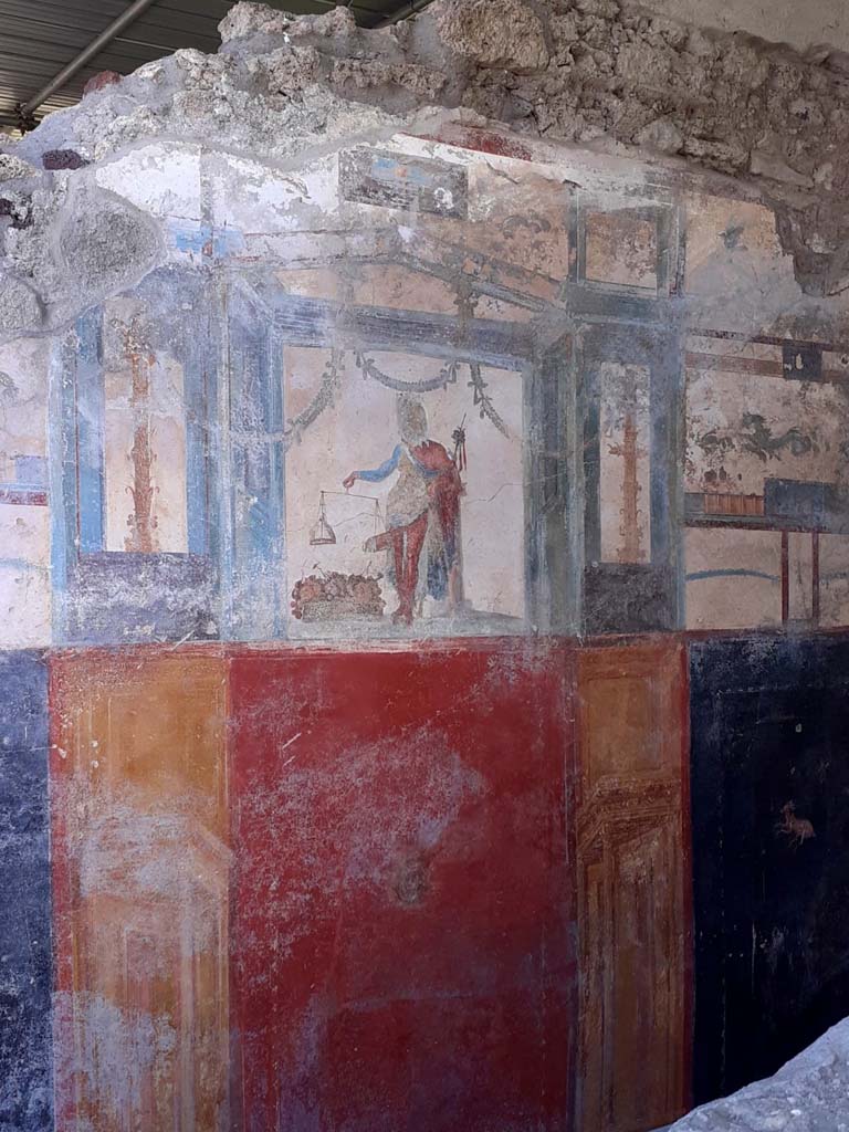 V.6.12 Pompeii. May 2021. North wall of fauces/entrance corridor with a central painting of Priapus.
Photo courtesy of Davide Peluso.
