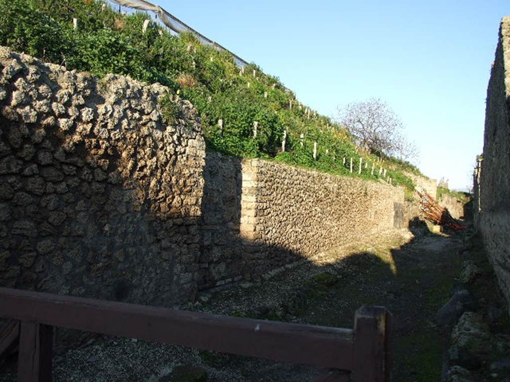 V.6 Vicolo delle Nozze d’Argento from Via del Vesuvio looking east at V.6.a/b/c. December 2006. The first blocked doorway,V.6.a on the left, would have been the rear entrance of V.6.1. According to Cooley, somewhere on the façade of V.6.b/c, that is between the second and third blocked doorway, CIL IV 7034 was found: 
Cn. Helvius Sabinus for [duum]vir.
(Cooley thought this was probably a mistake by the writer of the notice.
According to Cooley,  Marcus Epidius Sabinus was a candidate for duumvir in the same year as Helvius Sabinus was candidate for aedile.
This is what presumably confused the writer of the graffito.)
According to Epigraphik-Datenbank Clauss/Slaby (See www.manfredclauss.de), it would have read
Cn(aeus) Helvium Sabinum [II] vir(um)    [CIL IV 7034].

