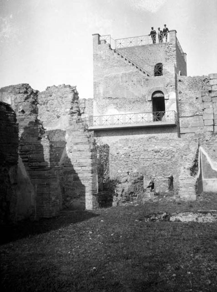 231224 Bestand-D-DAI-ROM-W.633.jpg
6.9.1 Pompeii. W633. Looking north inside atrium towards north-west corner and Tower XI, at rear. In the north-west corner was room 13, the kitchen containing steps to upper floor and latrine, in centre of photo. Room 12, an oecus was on the right side of the kitchen.
Photo by Tatiana Warscher. With kind permission of DAI Rome, whose copyright it remains. 
See http://arachne.uni-koeln.de/item/marbilderbestand/231224 
According to Warscher, “this photo was taken from the south end of the atrium. One could see the impluvium, a part of the kitchen, a part of ala “K”, and the section of the walls that separated the fauces, and room “d”.
See Warscher, T, 1938: Codex Topographicus Pompejanus, Regio VI, insula 9: Pars prima, (no.14), DAIR, Rome.  
