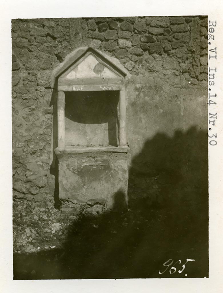 VI.14.30 Pompeii. Pre-1937-39. Aedicula against east wall of garden. 
Photo courtesy of American Academy in Rome, Photographic Archive. Warsher collection no. 965.

According to Boyce, against the east wall of the garden stands an aedicula. 
Above a solid base, two columns without capitals support a pediment. 
In the tympanum is painted a large aquatic bird of reddish colour with wings spread.
It stands upon a black cloth, across its wings lies a black cord ending in a bow-knot, on each side of the bird stands a green marine goat.
The base of the aedicula is black, adorned with a painted garland. 
The rear wall within the shrine is hollowed out in the form of a seashell and painted in imitation of one.
In the south wall of the same garden is a niche with projecting floor and vaulted ceiling.
Its walls are adorned with painted plants, flowers and birds.
We can only speculate on the purpose of this niche. 
Presumably the aedicula is the lararium, the niche probably contained a figure of primarily decorative character.
See Boyce G. K., 1937. Corpus of the Lararia of Pompeii. Rome: MAAR 14. (p.53, no.203, and Pl. 35,1)

According to Giacobello, the painted decoration on the aedicula and architecture has disappeared, leaving only the stone podium and the niche. 
The wall was decorated with a rich garden painting.
Regarding the niche on the south wall of garden, originally painted with flowers, plants and birds, today disappeared, only the red plaster remains.
See Giacobello, F., 2008. Larari Pompeiani: Iconografia e culto dei Lari in ambito domestico. Milano: LED Edizioni. (p.275)

