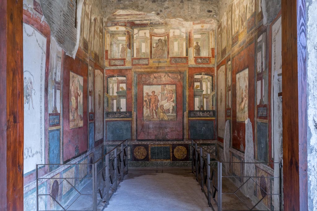 VI.15.1 Pompeii. March 2023. 
Looking east through doorway into exedra in north-east corner of peristyle. Photo courtesy of Johannes Eber.
