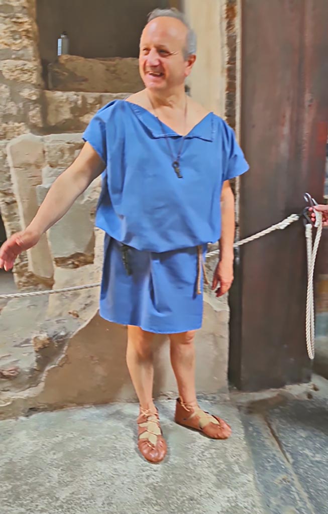 VI.15.1 Pompeii. 8th June 2024. Actor dressed in costume, “Come in”. 
Historical reconstruction entitled L’altra Pompei prende vita (The other Pompeii comes to life).
