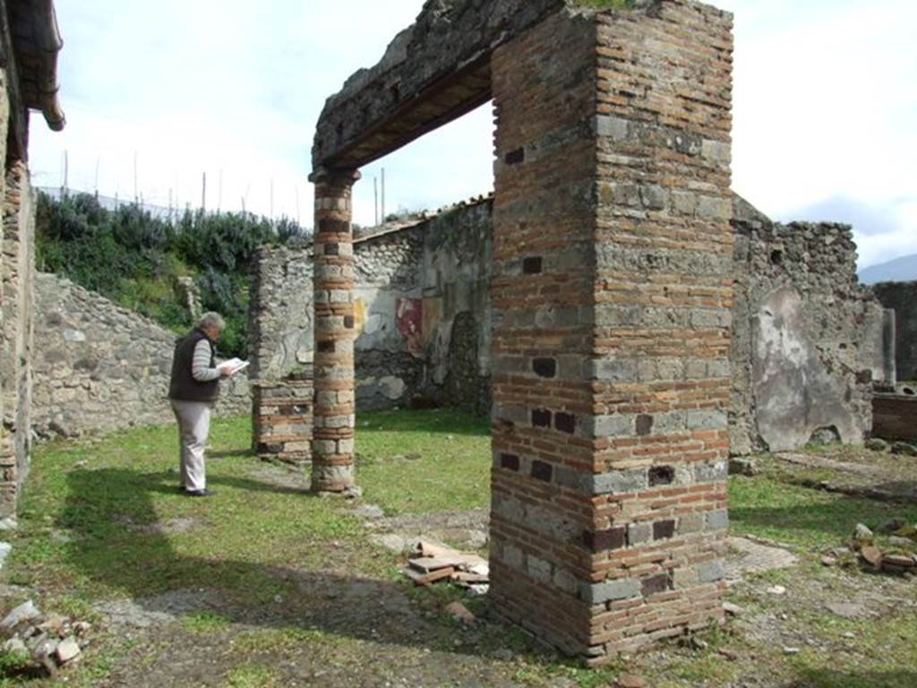 VI.16.27 Pompeii. March 2009. Room B, atrium of VI.16.26, looking south-east.  The pilaster was made of rows of bricks and tufa cut  into the manner of bricks, the remains of the column to the west was all brick (seen on right of photo), while the other was made of brick and limestone.
