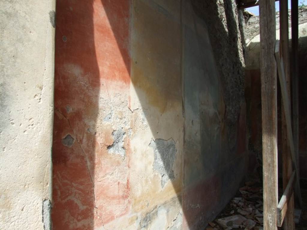 VI.16.28 Pompeii. March 2009. Room F, north wall, showing remains of red, yellow and green panels. According to NdS, The wall was divided into five parts, the central panel was green, the two either side of it were yellow, and the two at the ends were red. The central panel had a painting and was separated from the side panels by two slender columns. The panels of the north wall are divided by simple blackish bands. The upper zone had a white background and preserved a small part of the architectural decoration, and was of the third style. The dado had a red zone in correspondence with the central panel, and two black in correspondence with the four large side panels. See Notizie degli Scavi di Antichit, 1908, (p.273-4). According to PPP, in the centre of this wall was a painting of the Hunt of the Bulls, from which the house was also named. See Bragantini, de Vos, Badoni, 1983. Pitture e Pavimenti di Pompei, Parte 2. Rome: ICCD. (p.368).