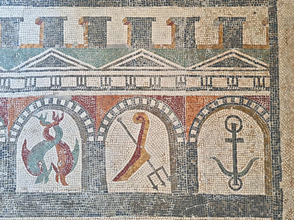 VI 17.10 Pompeii? July 2019. 
Detail from mosaic of “doors”, starting with a stern of a ship with rudder, a dolphin, and anchor, two dolphins, and a trident. 
On display in Naples Archaeological Museum. Photo courtesy of Giuseppe Ciaramella.
